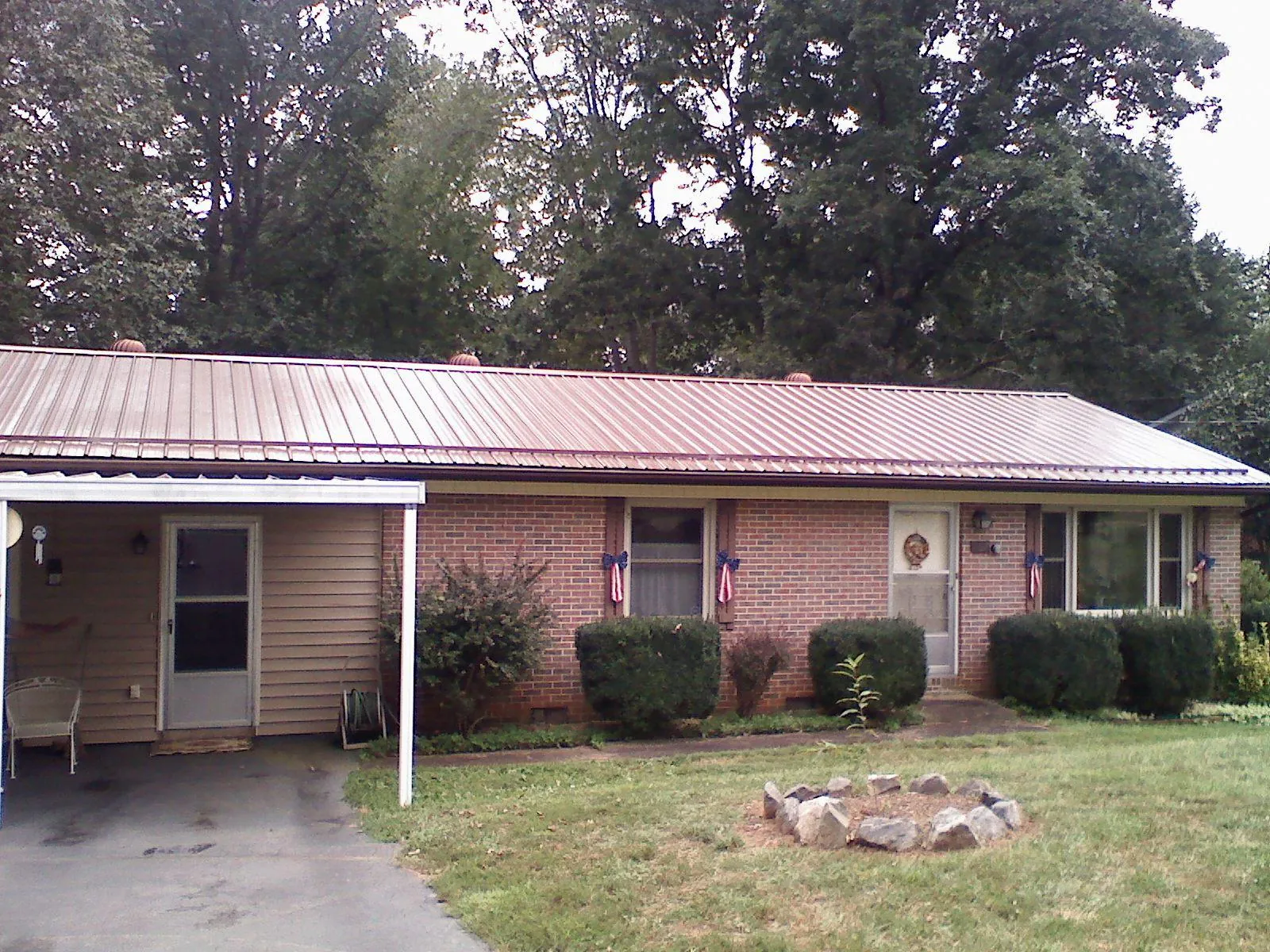 Bronze metal roof and carport on a brick ranch home — Roof Repair work by our crew in Alvord